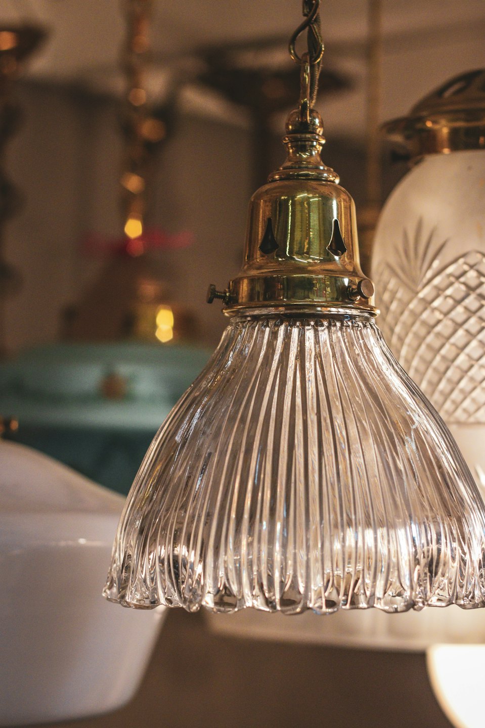Lampada a sospensione vintage con paralume in vetro a coste e raccordo in ottone.